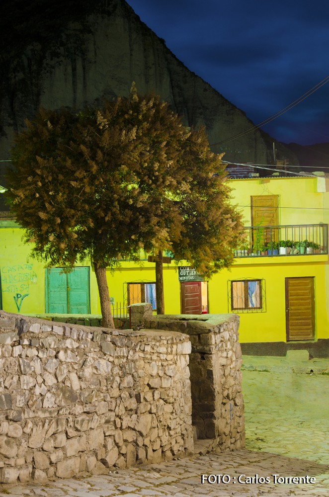 Noche en Iruya, una casa amarilla aparece tapada en parte por una planta de cedrón.
