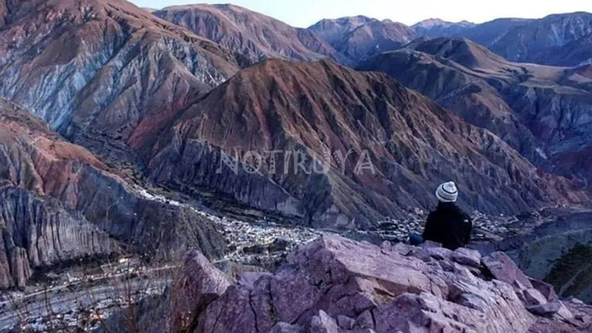 Una persona sentada en la montaña mirando hacia Iruya, que está abajo.